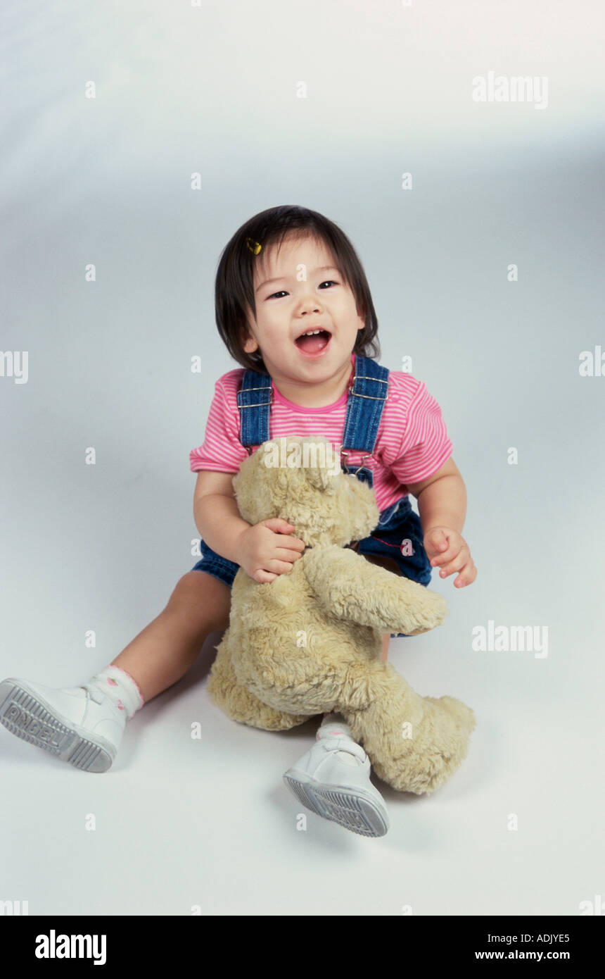 Baby girl playing with a teddy bear Stock Photo - Alamy