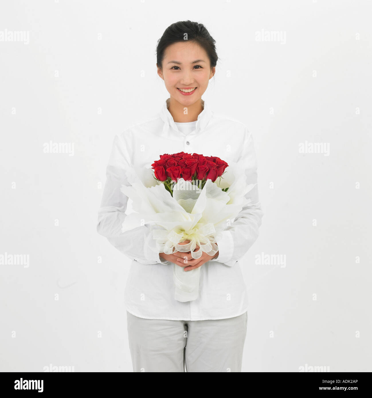 A young woman holding a bunch of flowers with a smile Stock Photo - Alamy