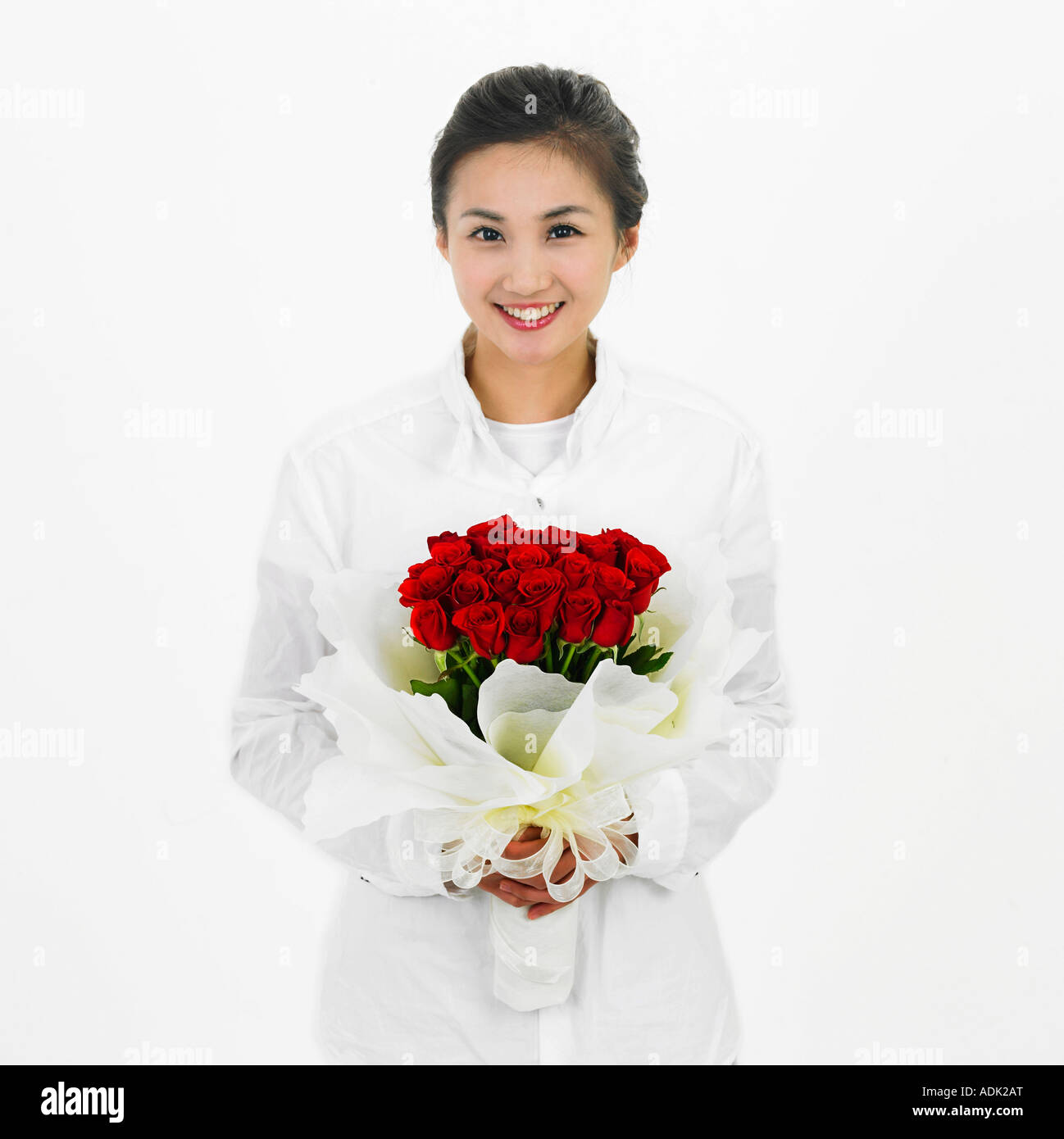 A young woman holding a bunch of flowers with a smile Stock Photo - Alamy