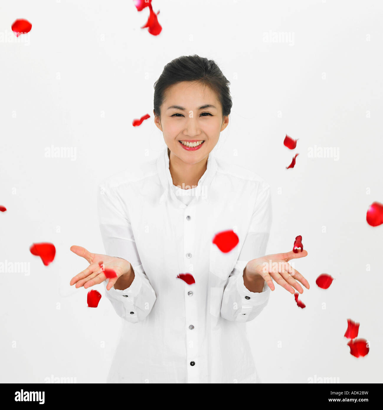 A young woman is amused by falling petals with a smile Stock Photo - Alamy