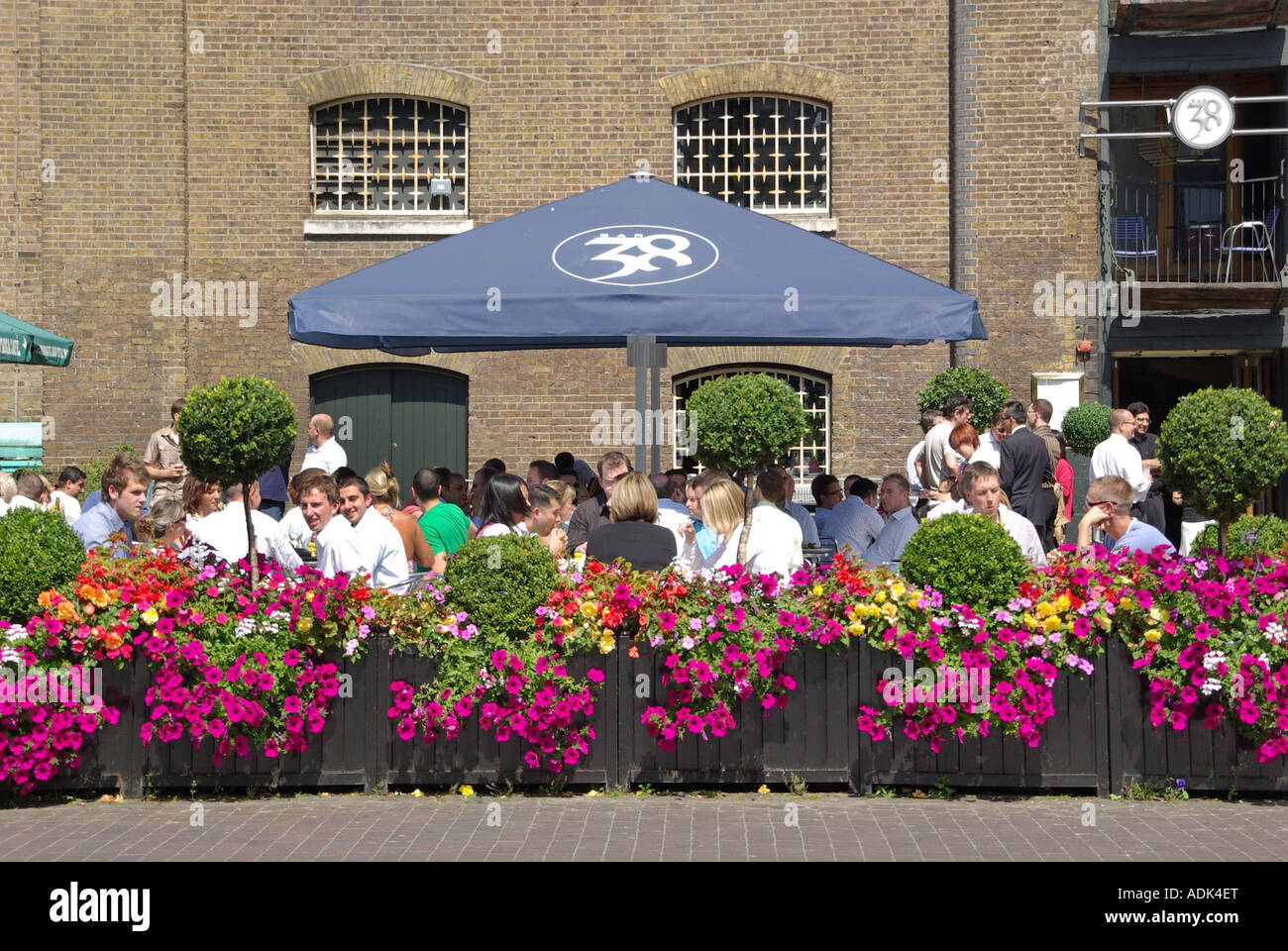 Warehouses converted to bars & restaurants in West India Quay alfresco eating out dining for Canary Wharf office business workers London Docklands UK Stock Photo