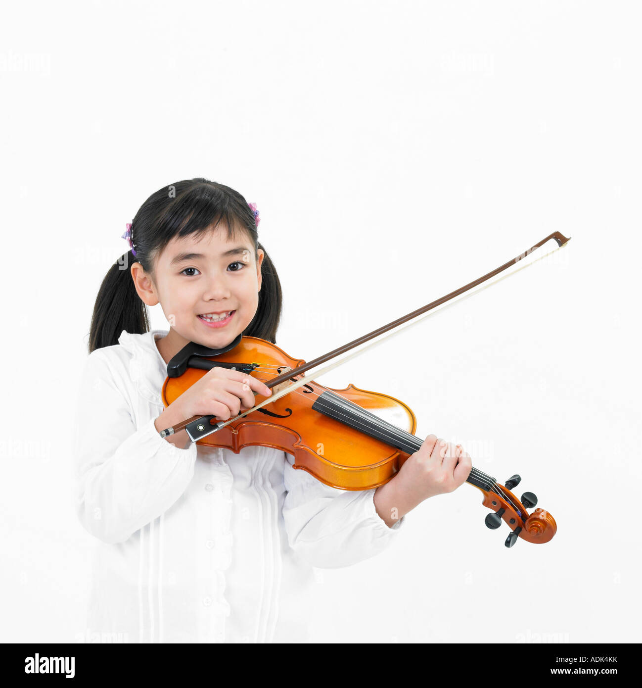 a girl playing the violin with a smile Stock Photo - Alamy