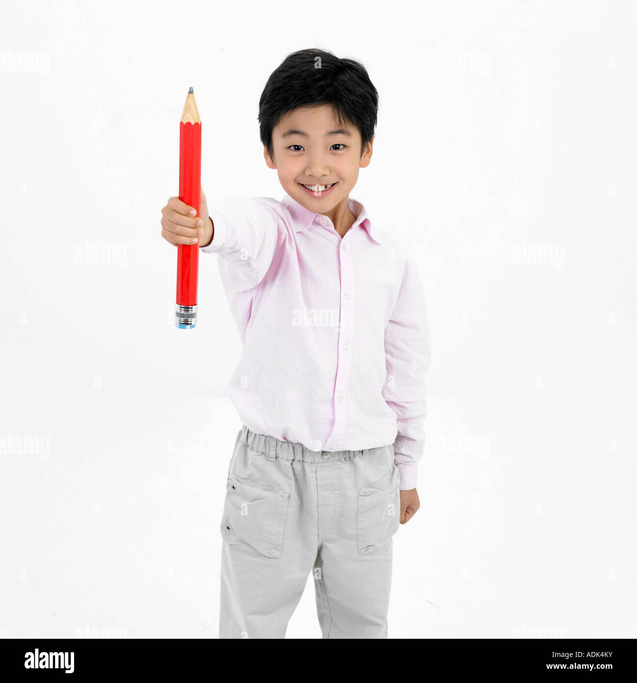a girl holding a big pencil with a smile Stock Photo - Alamy
