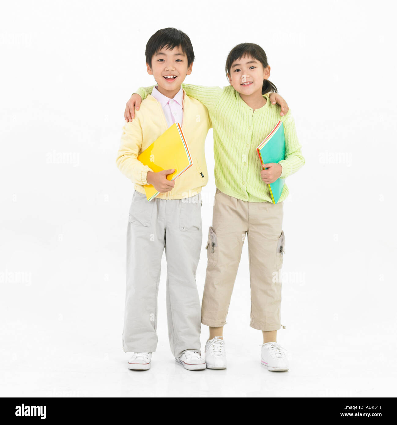 a boy and a girl putting arms around each other's shoulders Stock Photo