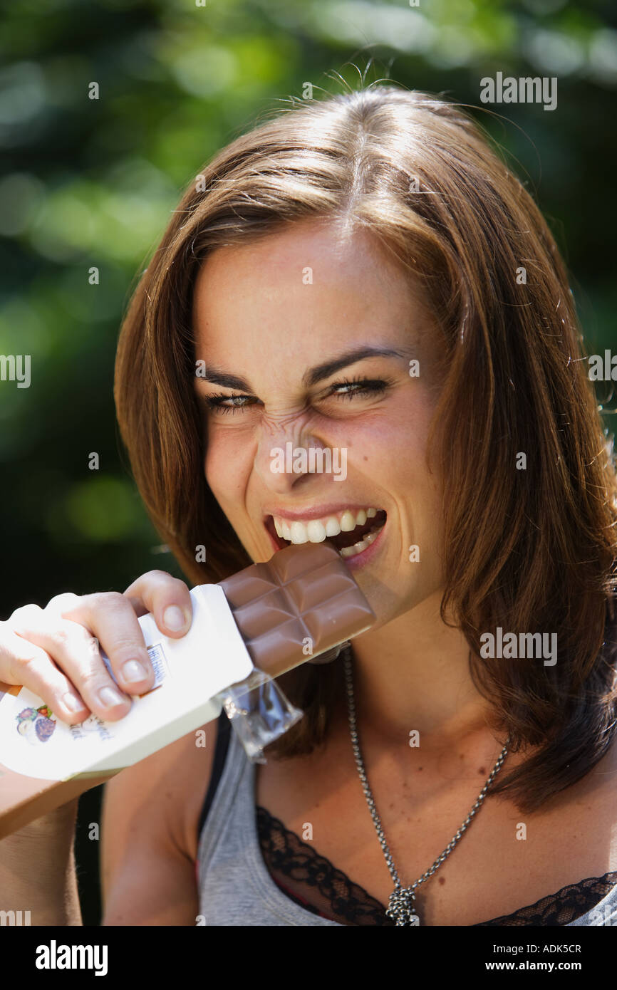 Young woman eats chocolate © Peter Schatz/Alamy Stock Photo
