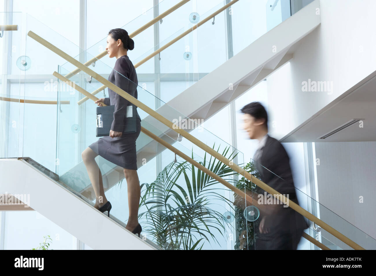 a businessman and a businesswoman ascending the stairs Stock Photo - Alamy