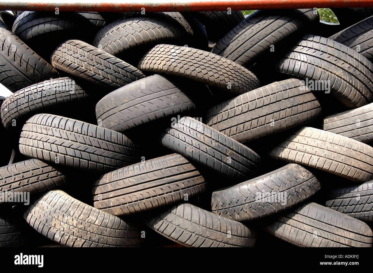 Worn out car tyres at a scrapyard wait to be shredded and recycled Stock Photo