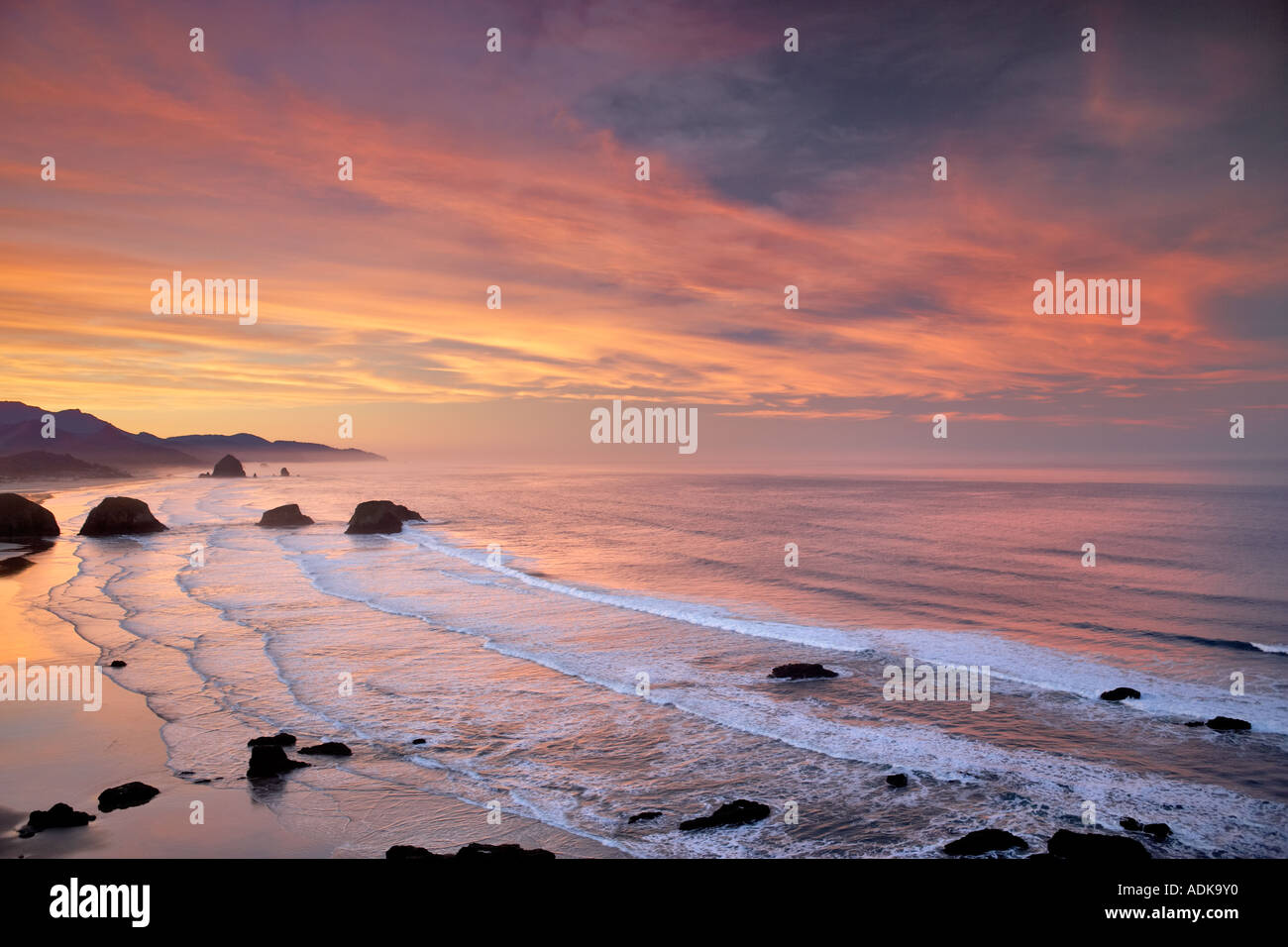 Sunrise and clouds with waves Cannon Beach Oregon Stock Photo