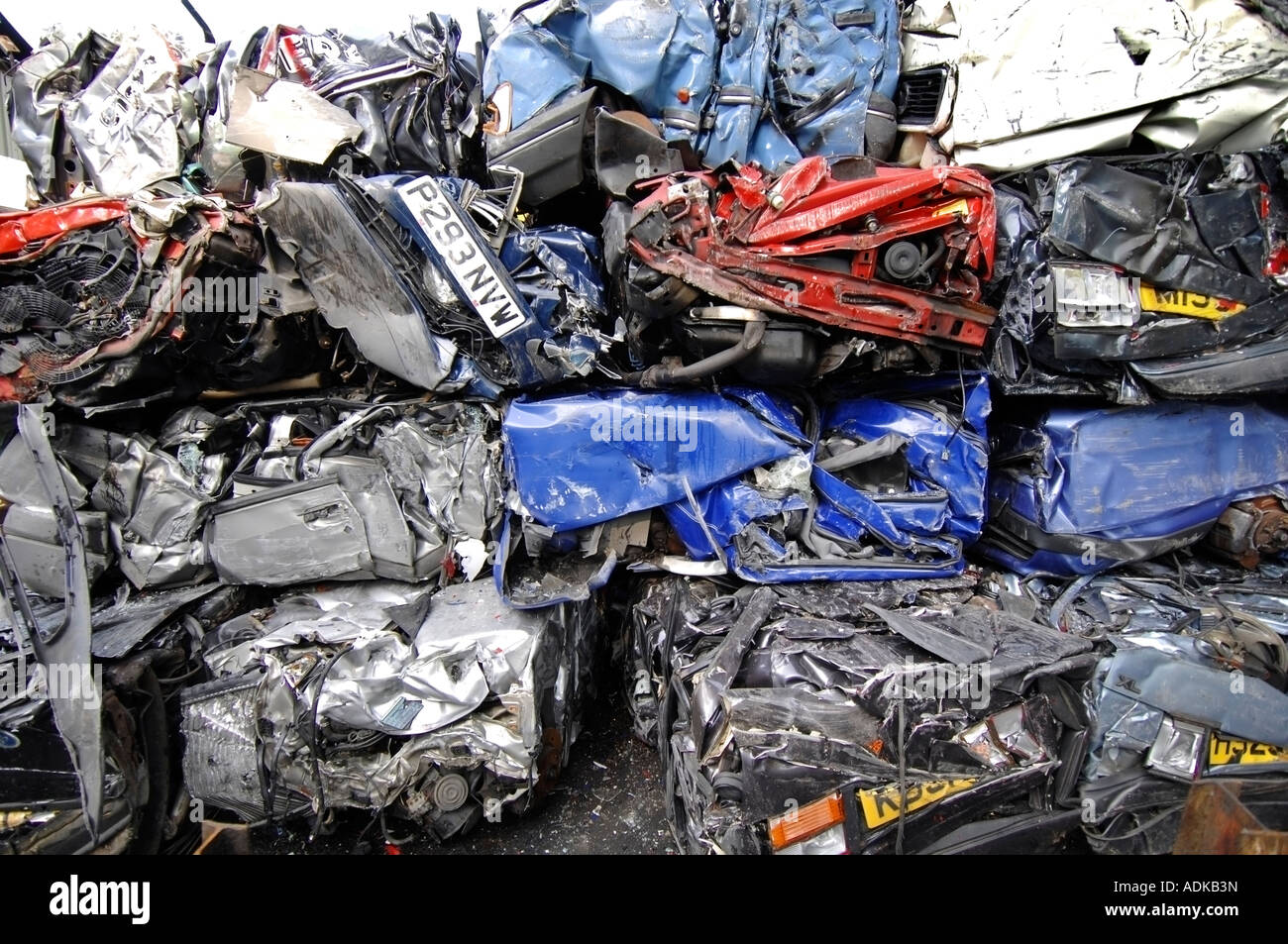 Cubes of crushed cars stand in a huge pile at a car recycling and
