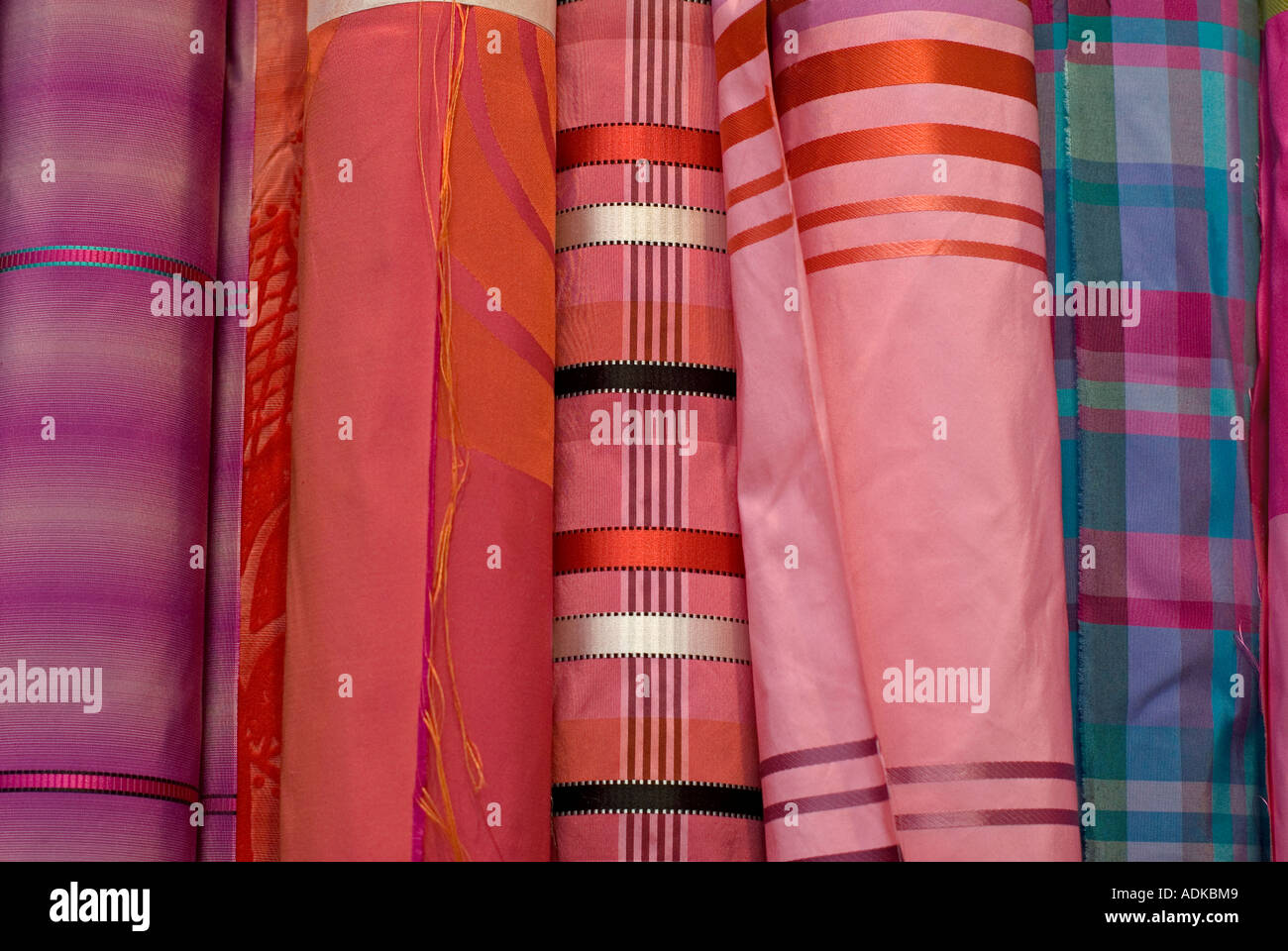 Stack of colourful fabrics on display in the shop window of the
