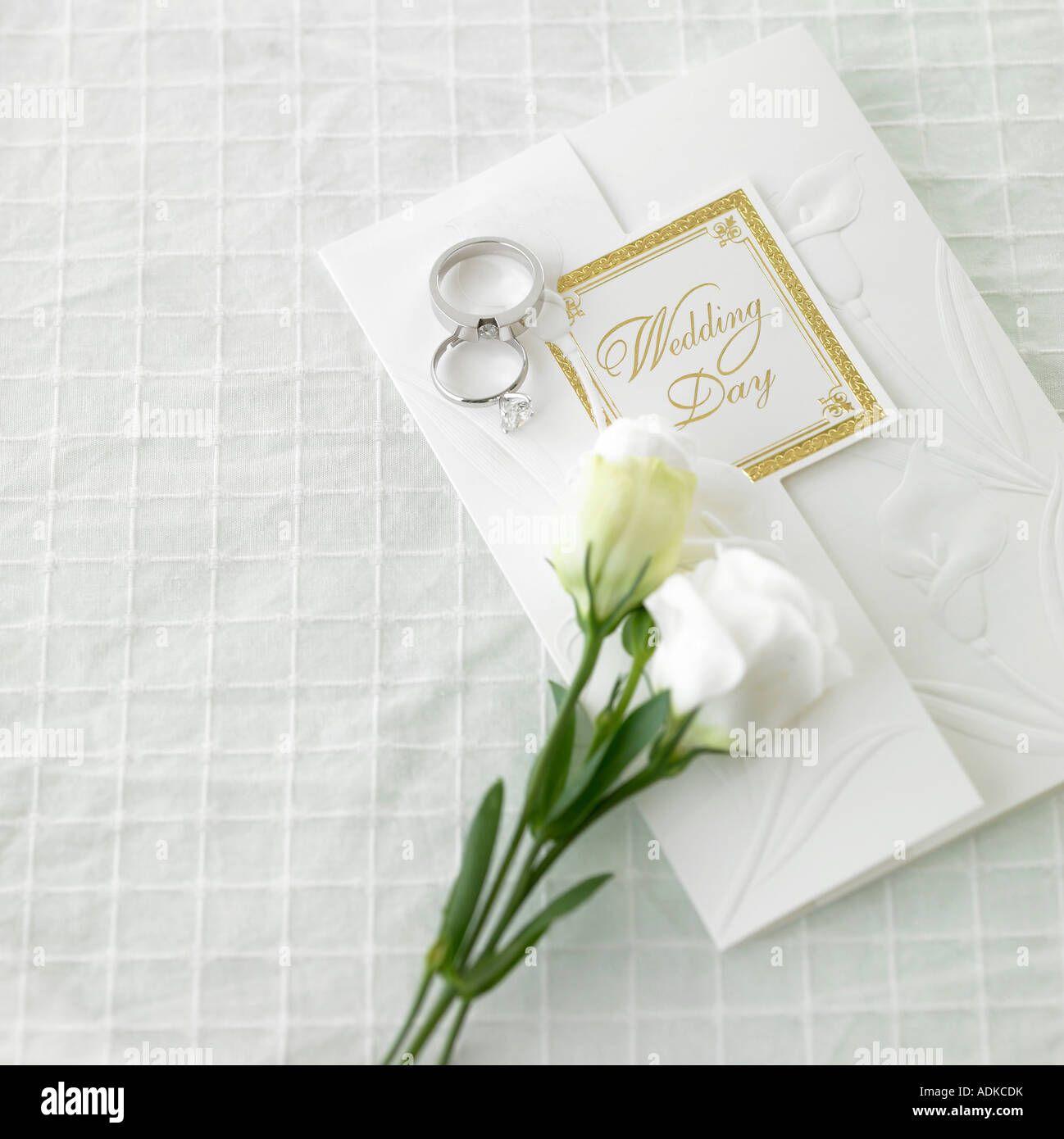 an invitation a wedding ring and a flower on the wedding veil Stock Photo