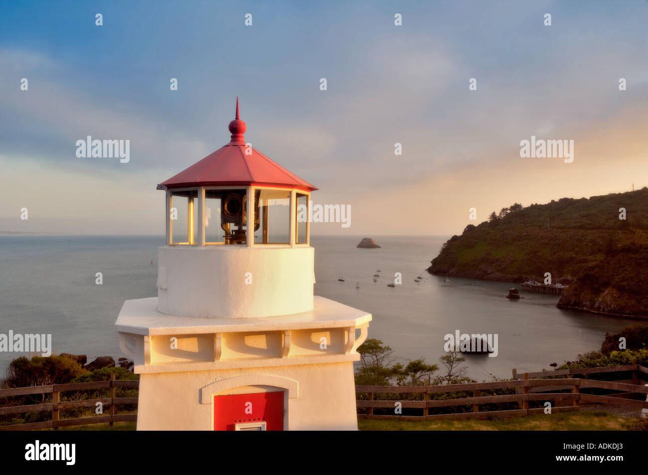Trinidad Lighthouse with boats in harbor and sunset California Stock Photo