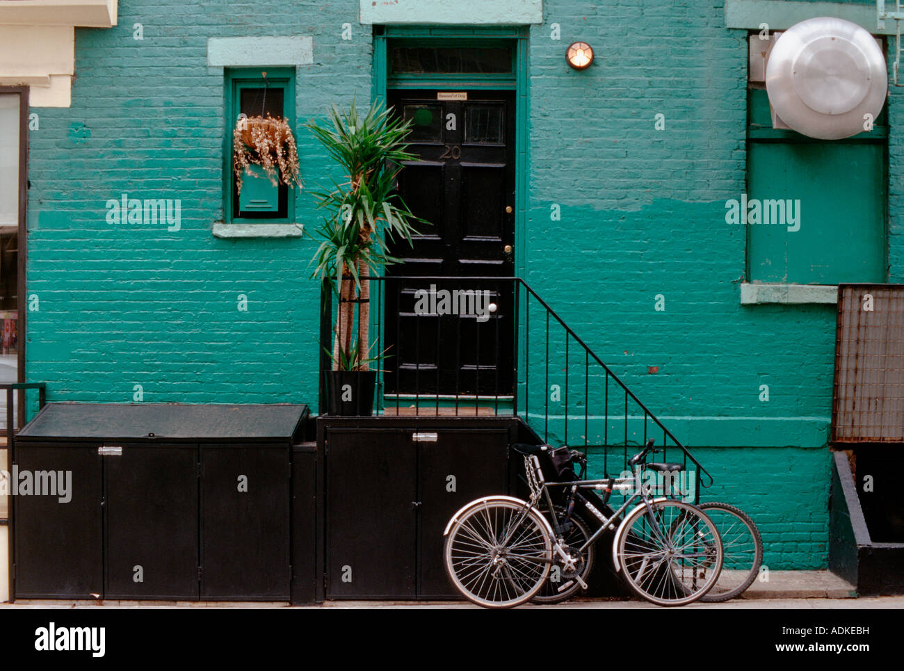 Green Turquoise Wall With Black Door And Steps With Bike