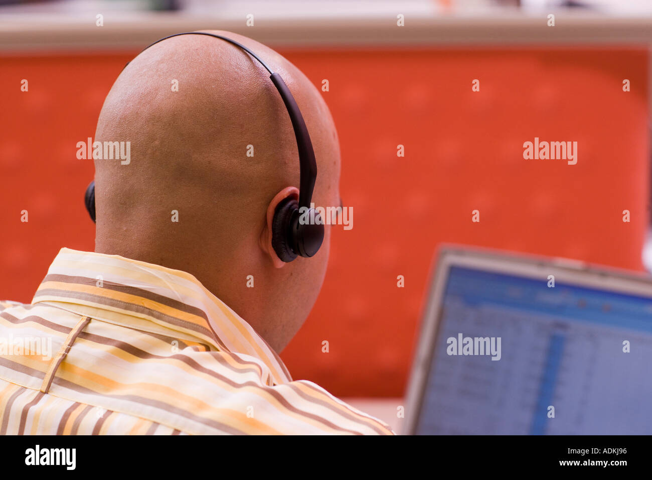 Rear view of a male customer service representative wearing a headset ...