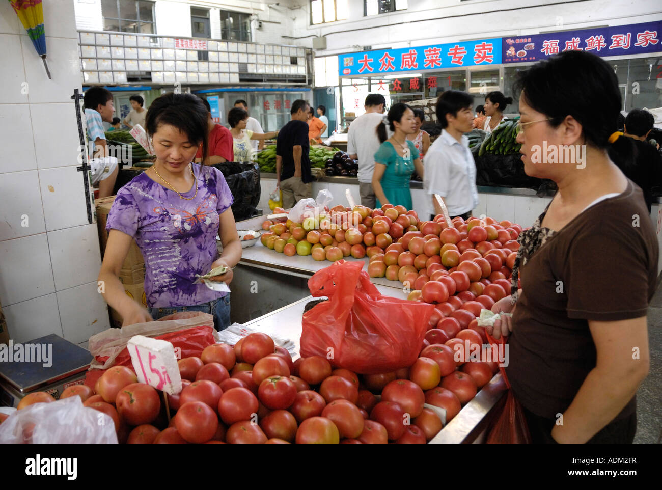 A woman buys tomatos in a food market in Beijing China 13 Aug 2007 Stock Photo