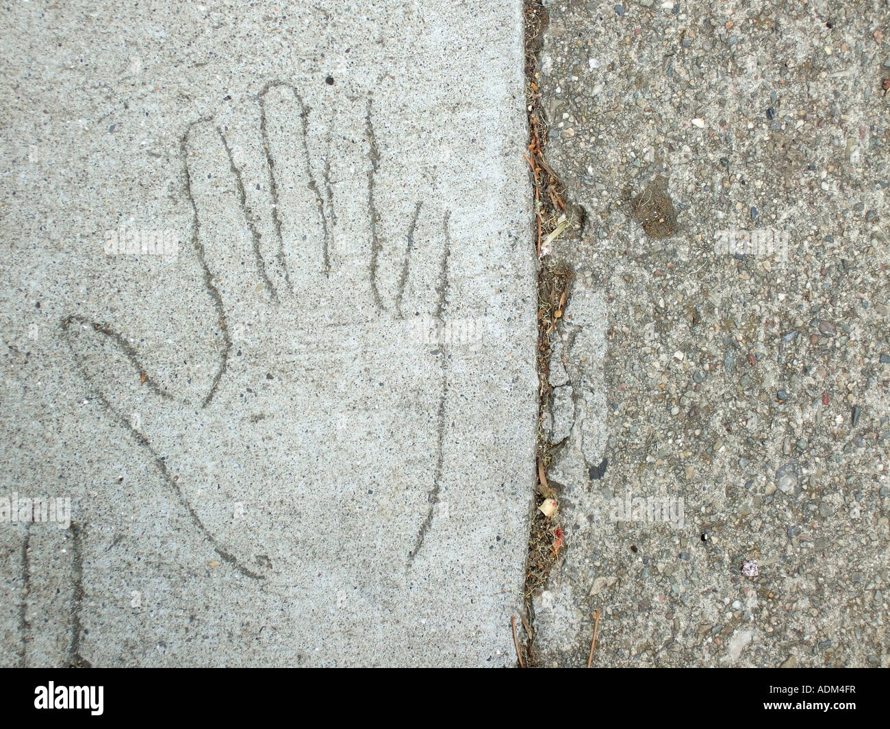 '^Outline of hand scratched in cement on sidewalk'. Stock Photo