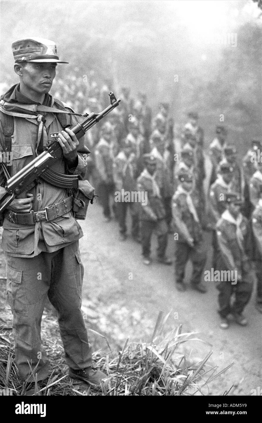 An ethnic Shan soldier stands guard over troops parading in the of the rebel army of the Shan State Army (SSA), Myanmar (Burma). Stock Photo