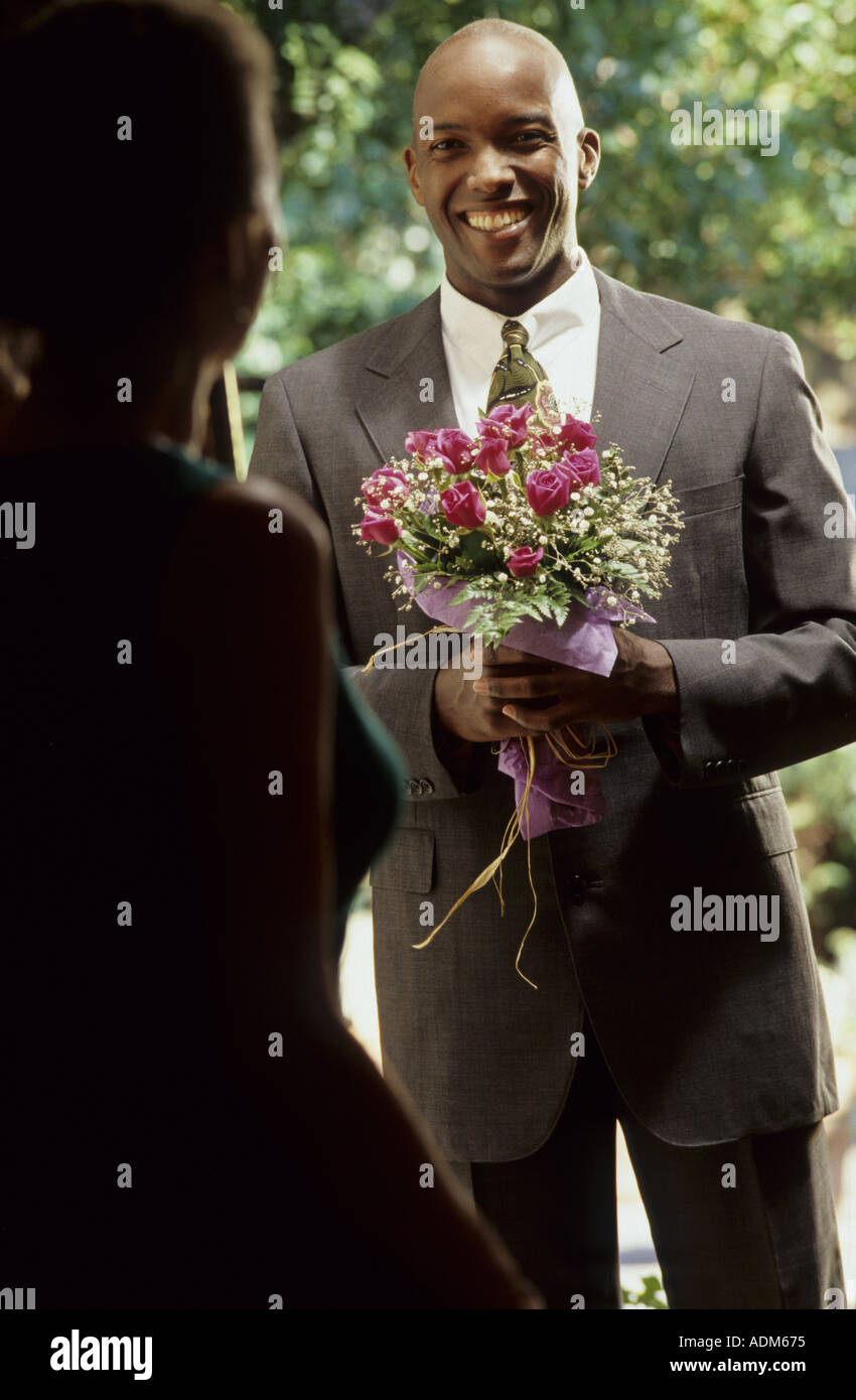 African American male bringing flowers to a woman Stock Photo