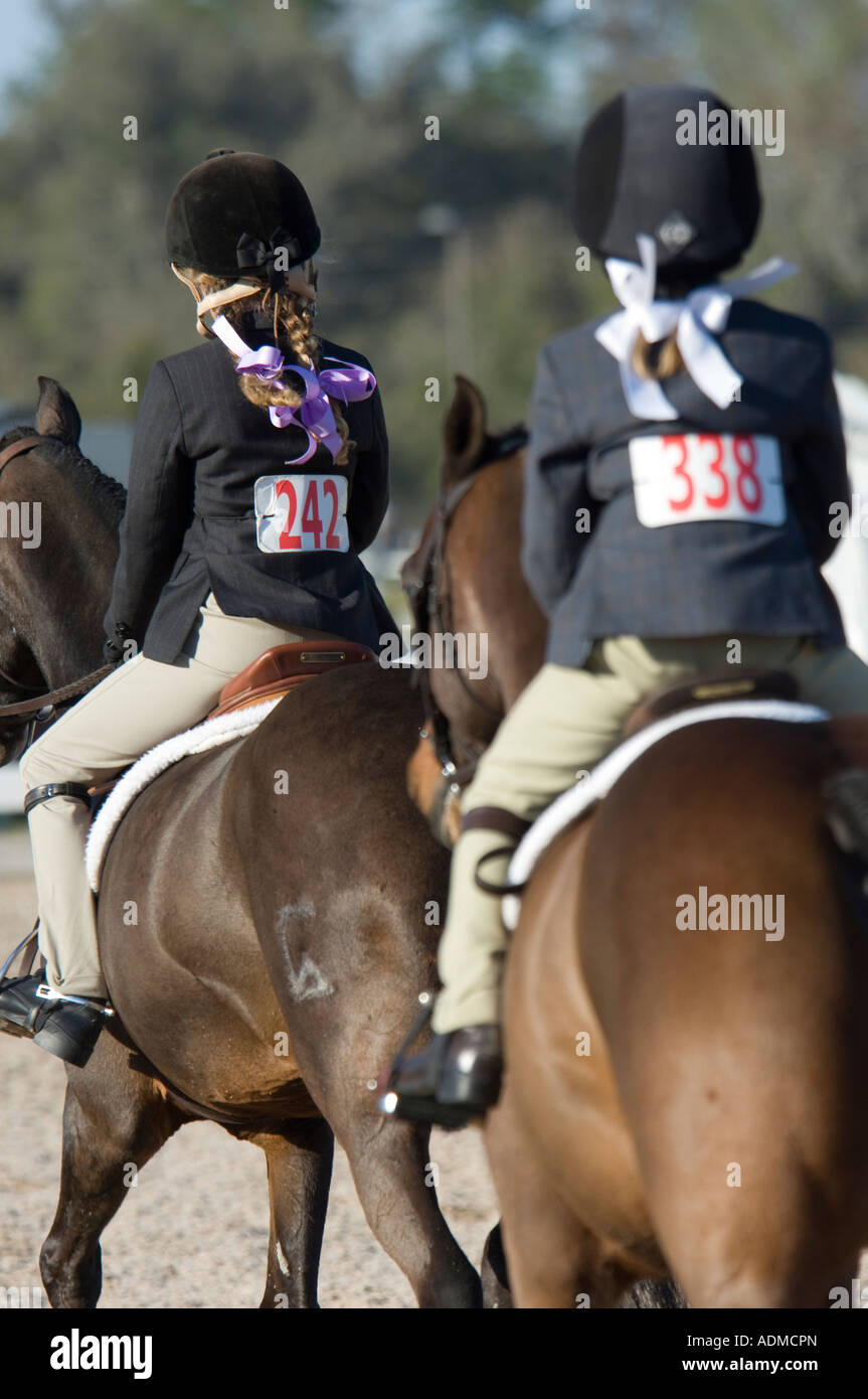 Pre teen girls and horses doing equitation at show jumping event Stock Photo