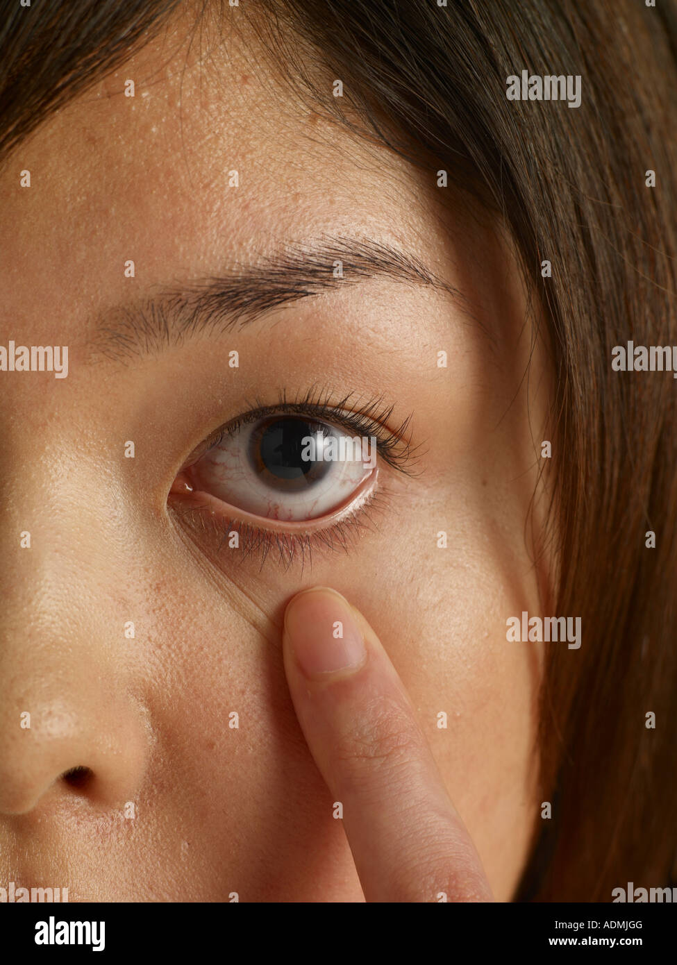Close up of woman s tugging at her lower eyelid Stock Photo