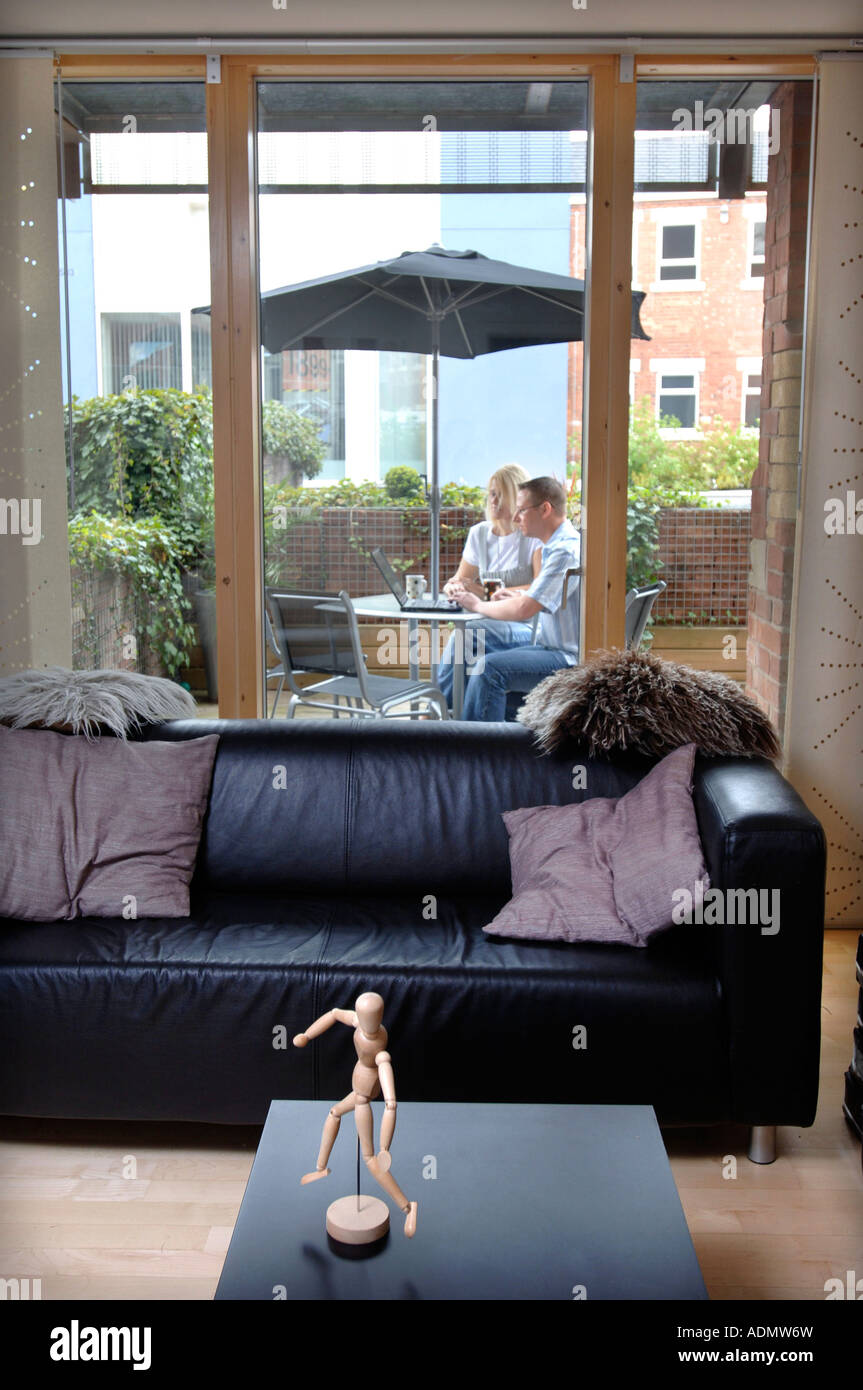 A COUPLE USING A LAPTOP ON THE BALCONY AREA OF A CONTEMPORARY STUDIO FLAT UK 2007 Stock Photo