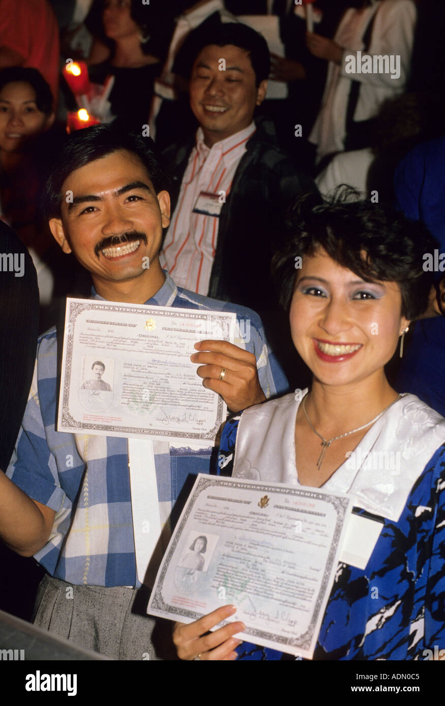 Asian couple show off American Citizenship certificates at ceremony  Stock Photo