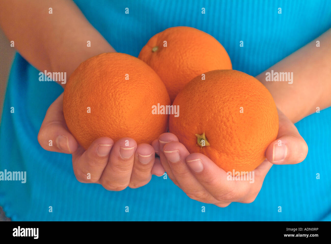 Two female hands holding ripe oranges Stock Photo