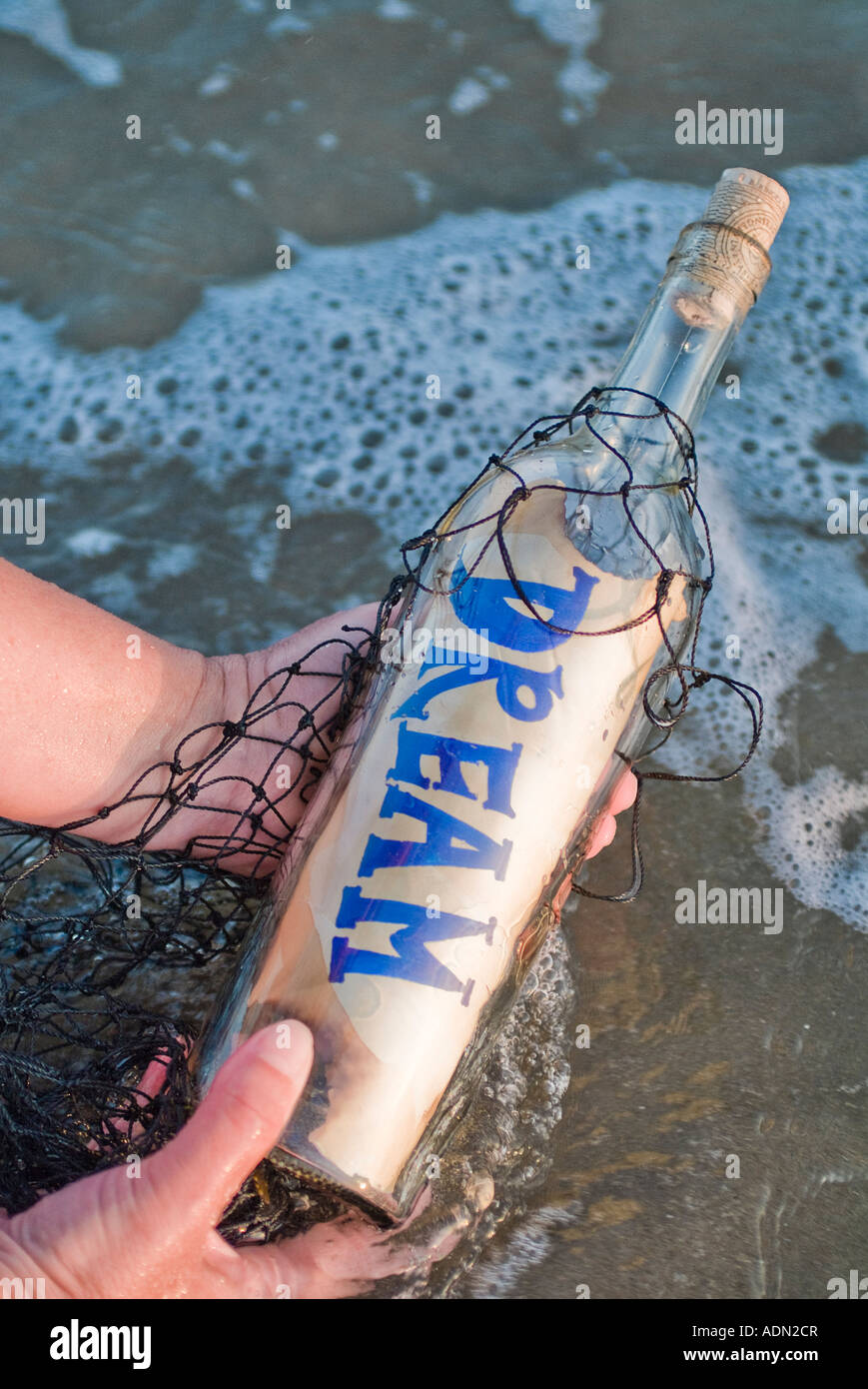 Bottle washed up on the beach with a message of dreaming depicting positive concepts Stock Photo