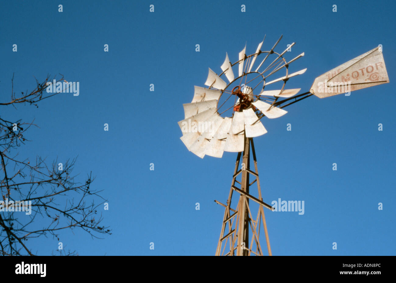 Windmill water vane pump used for agricultural and ranch irrigation against blue Texas sky Stock Photo