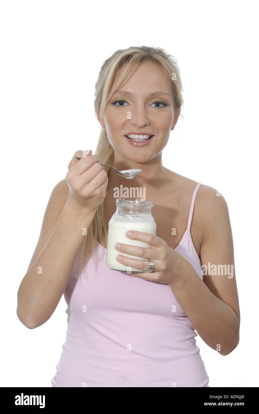 Junge Frau blond lacht laechelt freundlich positiv essen Genuss geniessen Joghurt Naturjoghurt Glas Stock Photo