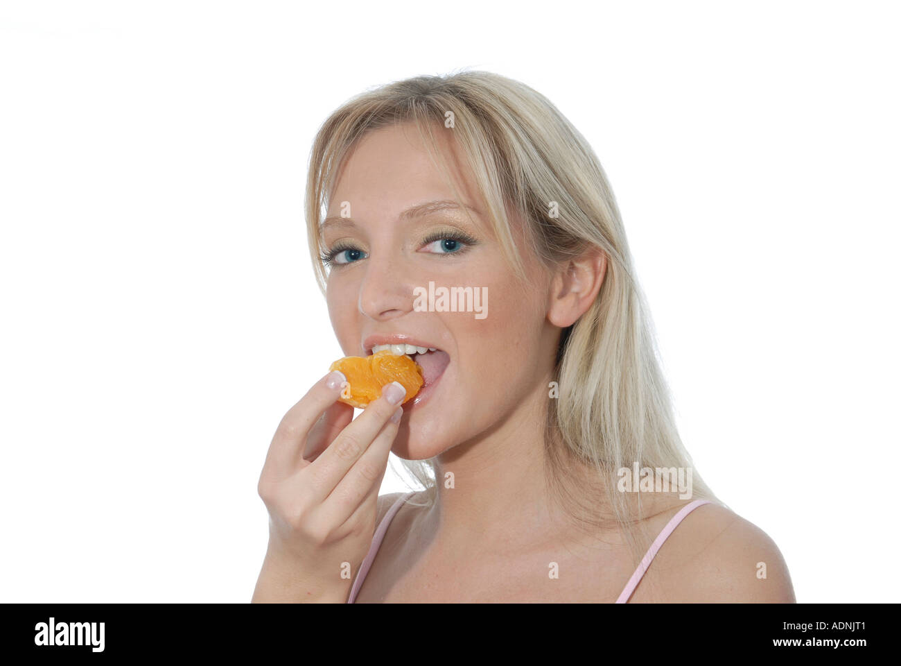 Junge Frau blond lacht laechelt freundlich positiv Orange essen Genuss geniessen Obst Vitamine Stock Photo