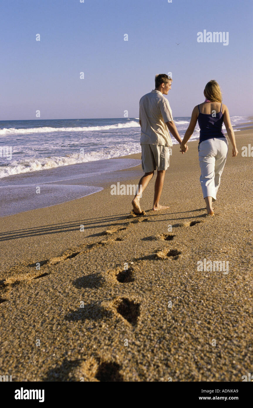 Rear view of a young couple walking on the beach Stock Photo - Alamy