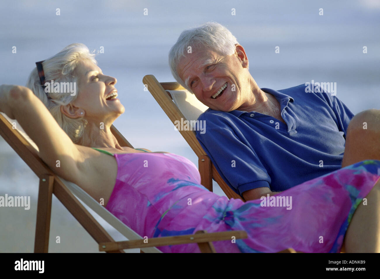 Senior couple sitting in deck chairs on the beach Stock Photo - Alamy