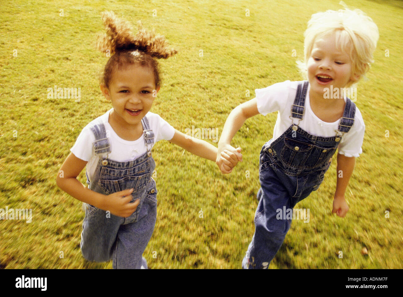 Portrait of two girls walking together on a lawn Stock Photo - Alamy