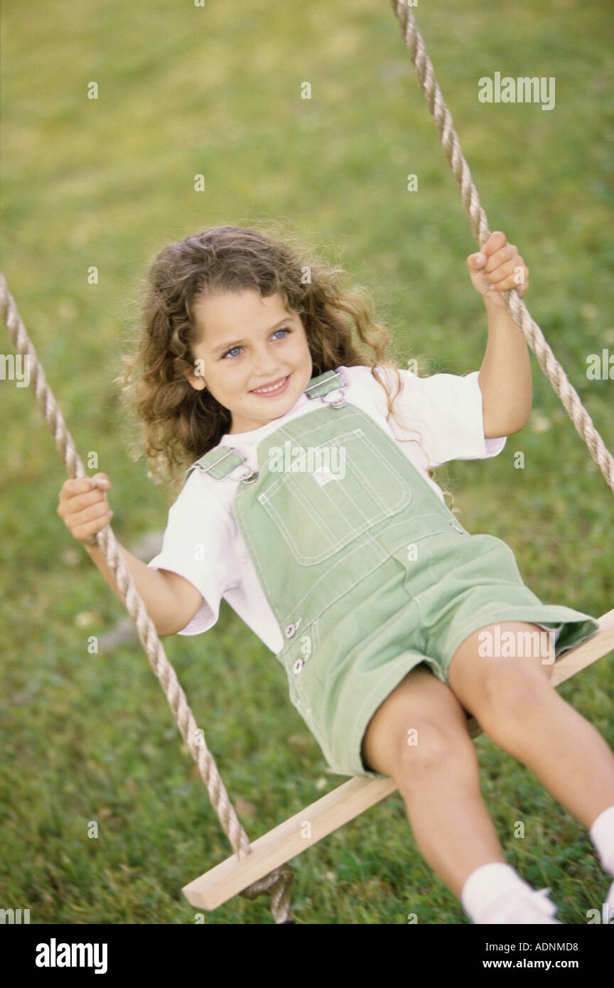 Front view of a girl sitting on a swing Stock Photo - Alamy
