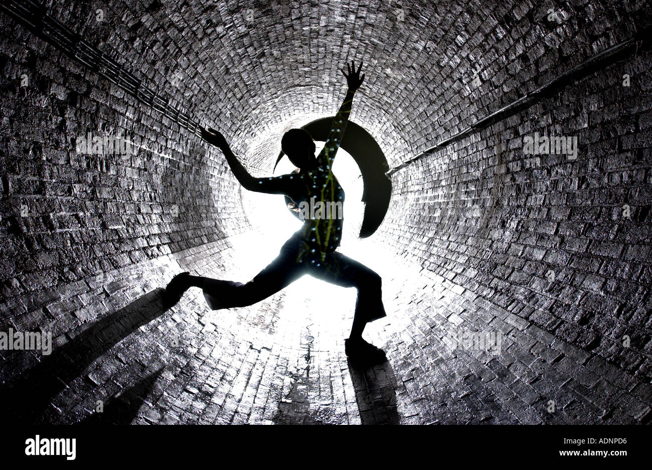 Underground movement Dancer puts on a show in a subterranean sewer tunnel Stock Photo