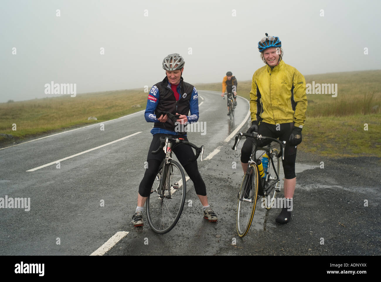 Two cyclists on the highest point of A4069 road on the Black Mountain between Brynaman and Llangadog west wales misty weather Stock Photo