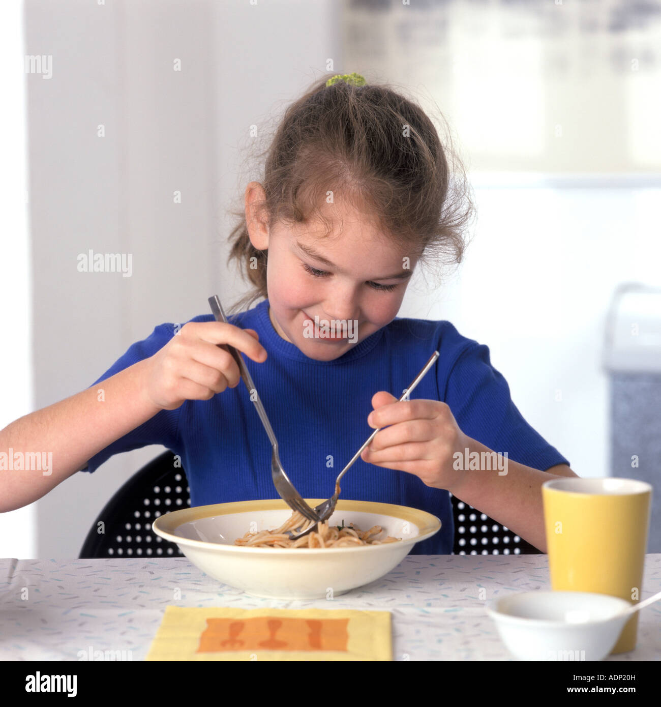 Girl eating pasta with a spoon and fork Stock Photo Alamy