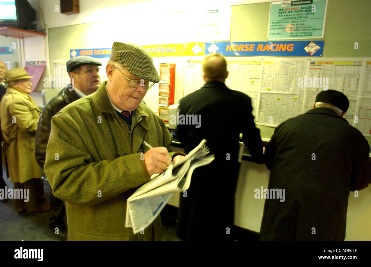 A racegoer marking his card in the Tote betting shop at the all weather racecourse at Lingfield Sussex UK Stock Photo