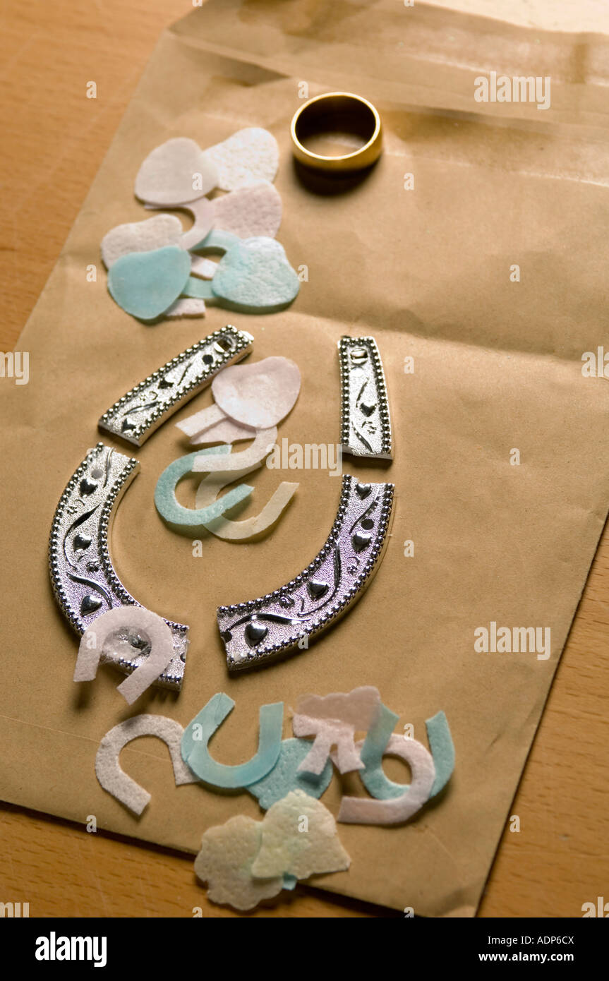 a broken wedding horseshoe and wedding ring with confetti Stock Photo