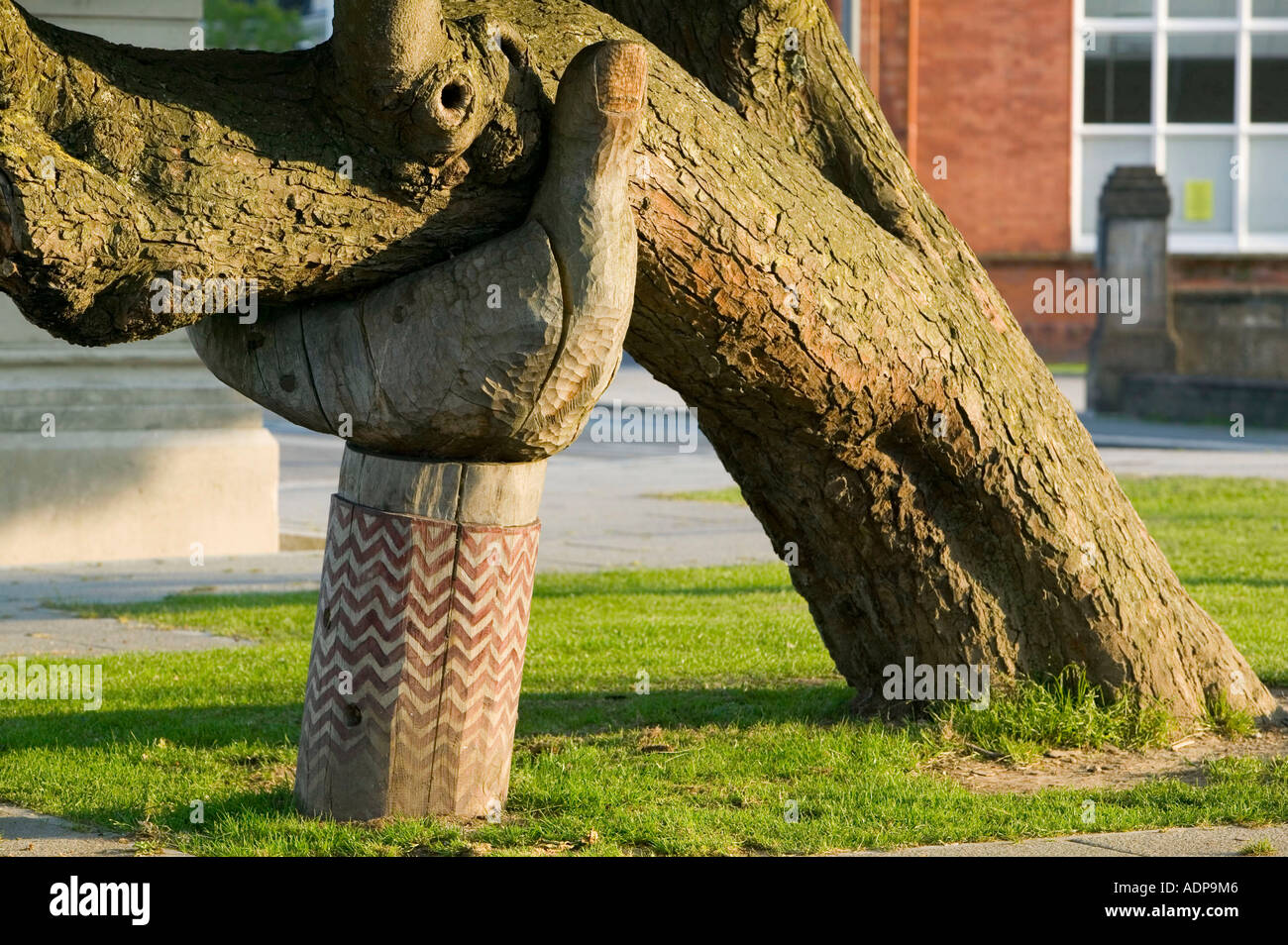 a wooden hand supporting a leaning tree in Bideford, Devon, UK Stock Photo