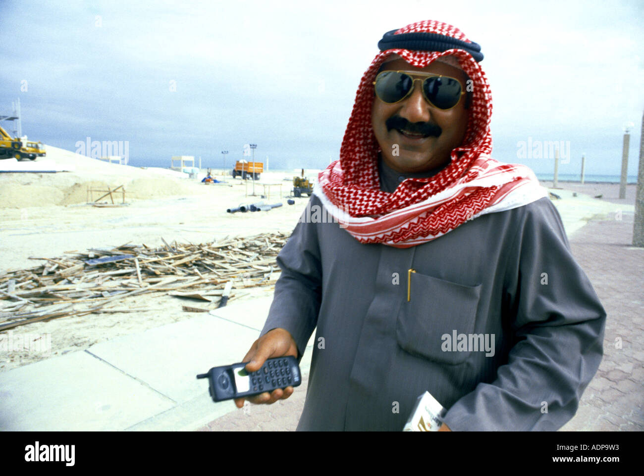 Kuwait City Kuwait Kuwaiti & Mobile Phone On Building Site Stock Photo