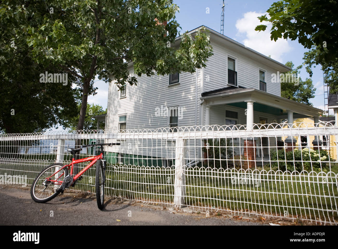 Red bicycle white fence Marysville Wolfe Island Ontario Canada 2007
