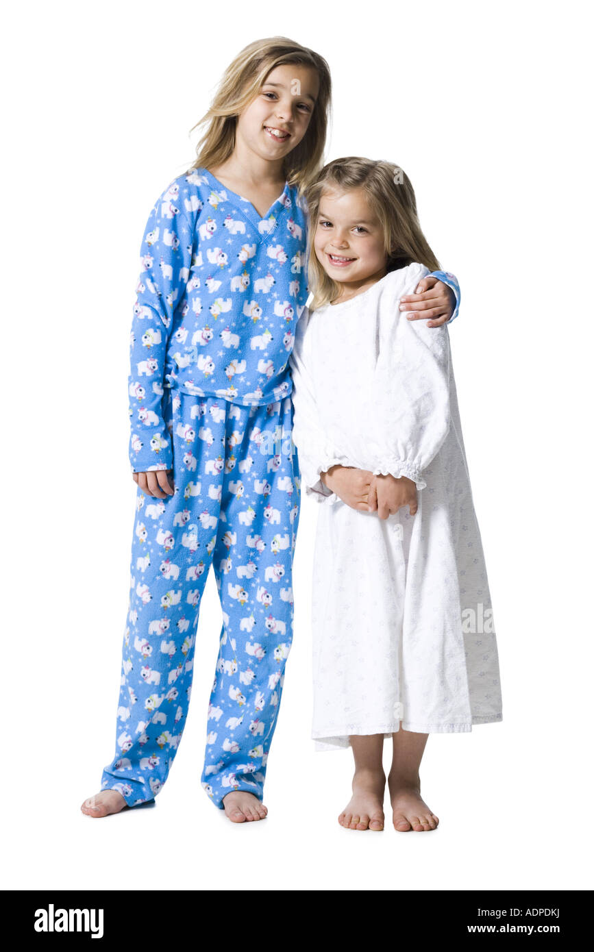 Two girls in pajamas hugging and smiling Stock Photo