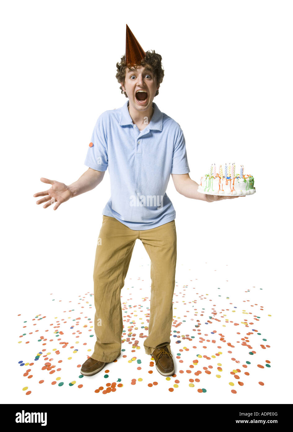 Man with party hat holding birthday cake Stock Photo