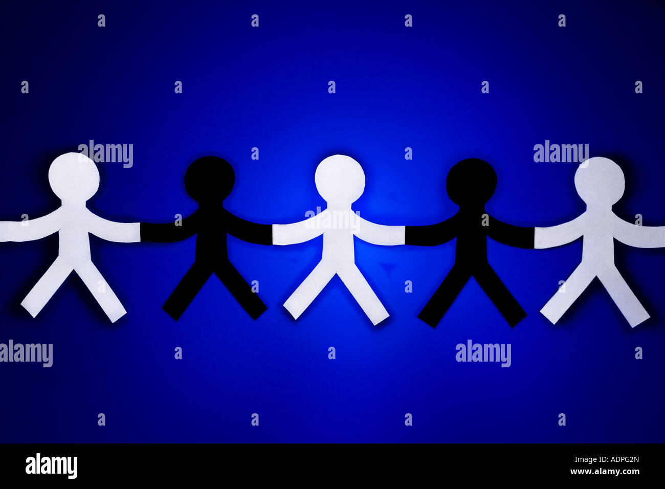 Five paper people cutouts three white and two black Stock Photo - Alamy