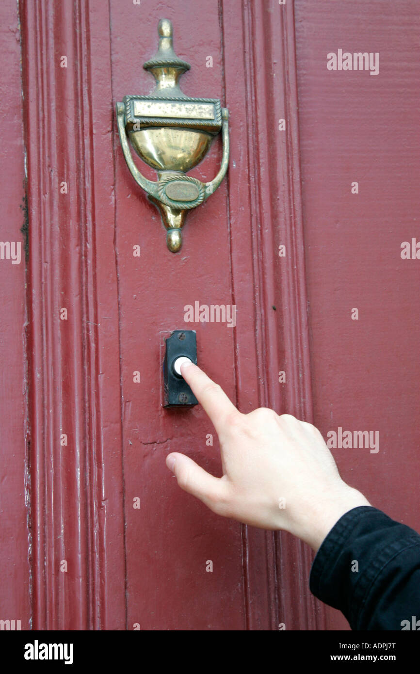 mans hand pressing finger to doorbell cold calling household Stock Photo