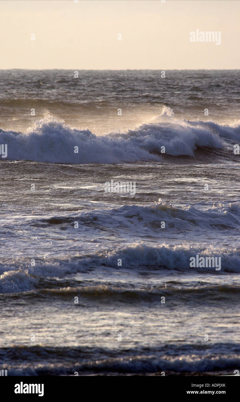 Waves on the Pacific Ocean in the late afternoon with the wind blowing spray off the top of the waves Stock Photo
