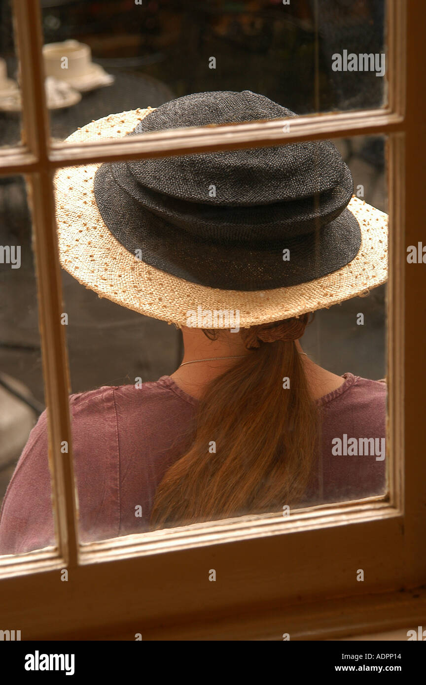 Woman in hat in coffee shop window in 