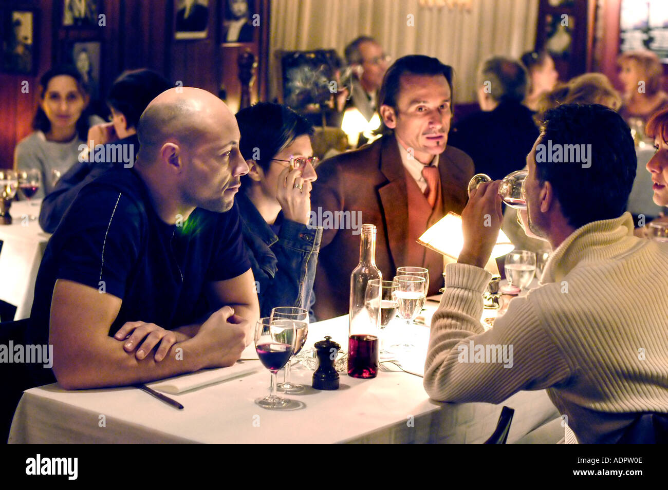 PARIS France, Adults, Sharing Drinks, Around Table in French Bistro Restaurant, 'Chez Arthur' Conversation, group of friends on holiday city, lights Stock Photo